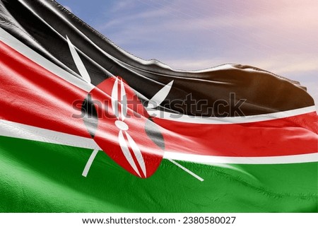 Kenya national flag waving in beautiful sky.