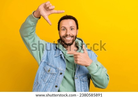 Photo portrait of attractive young guy arms show gesture fingers photo frame wear trendy khaki garment isolated on yellow color background
