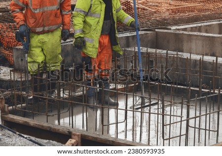 Concrete cast-in-place work. Builder level wet concrete. Concrete works on buildiiing construction site Royalty-Free Stock Photo #2380593935