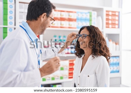 Man and woman pharmacist and customer wearing glasses at pharmacy Royalty-Free Stock Photo #2380595159