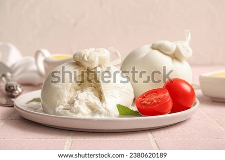Plate with tasty Burrata cheese on table