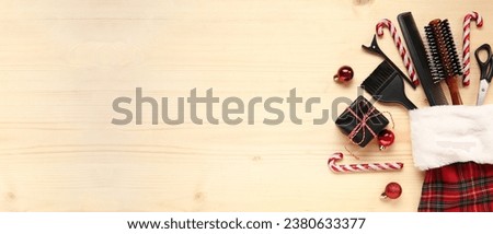 Hairdresser's supplies with Christmas sock and decor on wooden background with space for text