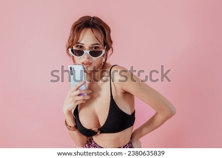A fashion forward pose against a pink backdrop, merging the classic charm of retro sunglasses with the modern allure of a sleek smartphone. A blend of the past and present, elegantly combined