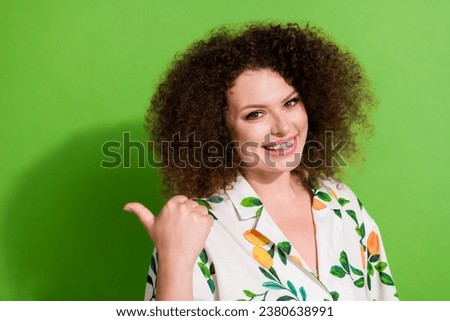 Portrait of lovely positive lady beaming smile indicate thumb finger empty space ad isolated on green color background