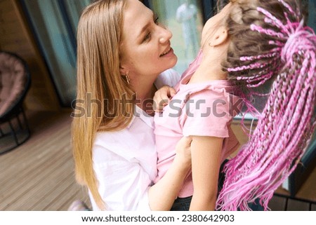 Caring mother looking at her little daughter with love and tenderness