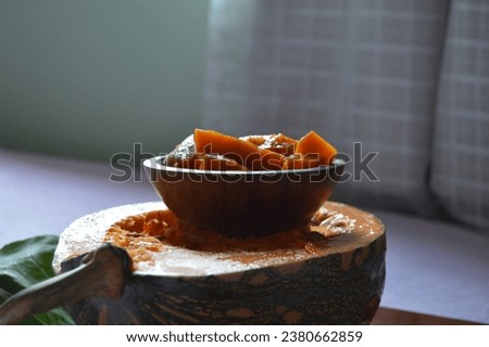Focus on the pumpkin pieces cooked in olive oil and served in the wooden bowl. Delicious autumn recipe with chopped pumpkin