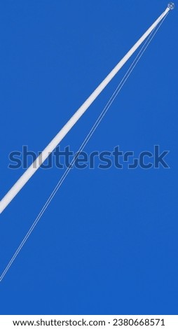 Aminimalist picture of Single flagpole with no flag, on blue sky background