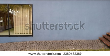 large window with autumn view and blue wall.