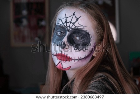 Young girl with painted skull on her face. Celebration of Mexico's Day of the Dead (El Dia de Muertos)