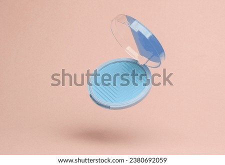 Blue Powder box flying in antigravity on pink background with shadow. Levitation object in the air. Beauty and fashion concept. Creative minimalist layout