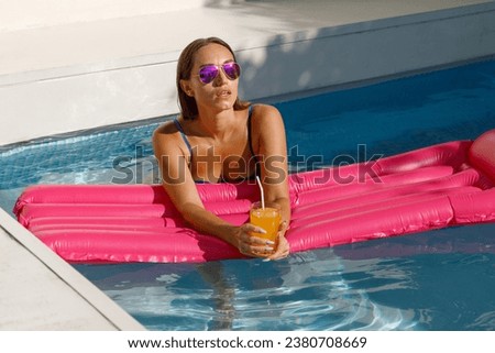 Chic Summer Days: Stylish Girl on Inflatable Raft in Pool