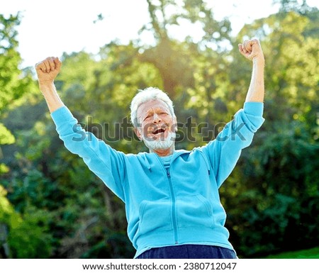 Smiling active senior man jogging exercising and having fun and celebrating success rasing hands taking a break in the park, concept of competition, winning, victory and strength Royalty-Free Stock Photo #2380712047