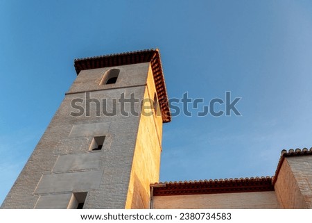 Stone tower at church in Granada, Spain, at sunrise on a clear day