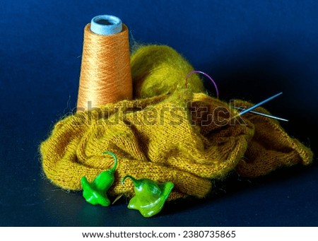 Knitted work in progress, cozy atmosphere, women's hobby knitting, the beginning of the process of knitting a women's sweater, color thread for knitting, Knitting concept