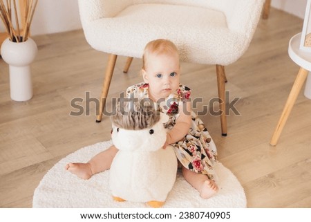 A child plays with a toy. A child sits on a toy. Soft toy
