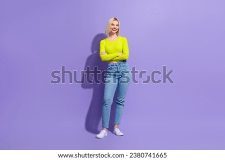 Full length photo of good mood pleasant woman dressed yellow clothes jeans standing hold palms crossed isolated on purple color background