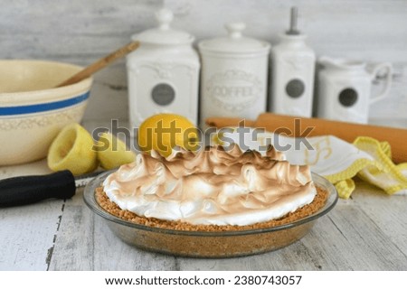 Homemade lemon meringue pie in a graham cracker crust made from scratch at home in a bright kitchen