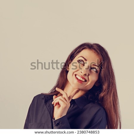 Beautiful confident calm thinking smiling business woman standing and looking in black cotton style shirt on blue light background with empty copy space for text. Closeup toned vintage color portrait