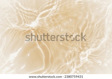 Defocus blurred transparent gold colored clear calm water surface texture with splashes reflection. Trendy abstract nature background. Water waves in sunlight with copy space. Blue watercolor shine. Royalty-Free Stock Photo #2380759431