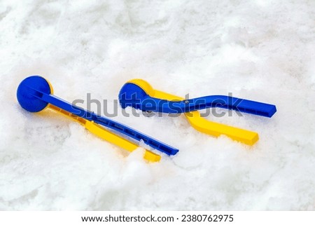 Yellow and blue plastic snow ball maker for winter fun on holidays on snow.