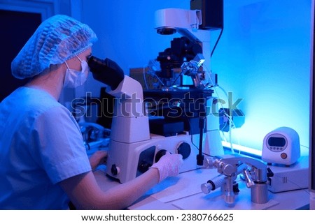 Lab female scientist is performing ICSI procedure with micromanipulation device Royalty-Free Stock Photo #2380766625