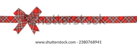 Red, green and white plaid Christmas gift bow and ribbon. Long border isolated on a white background.