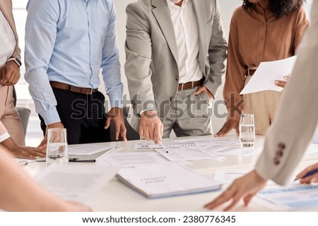 Executive business team people group working with paperwork standing at table, analyzing corporate strategy concept, reviewing plan, managing financial project overview at office meeting, close up. Royalty-Free Stock Photo #2380776345