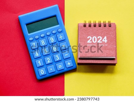 Mini calendar and calculator on coloured background. Saving and finance concept
