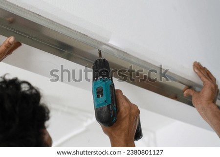 man use electrical drill to drilling  square steel bar Royalty-Free Stock Photo #2380801127