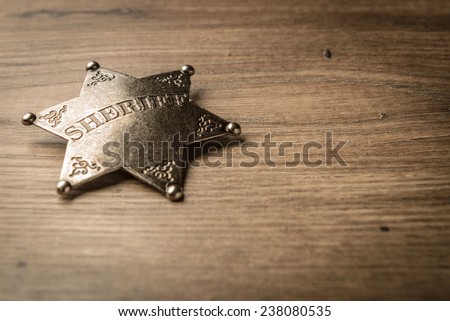 Vintage Wild West Sheriff badge on a rustic wood background. Royalty-Free Stock Photo #238080535