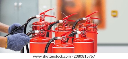 Fire extinguisher has hand engineer checking pressure gauges with exit door to prepare fire equipment for protection in emergency case and safety or rescue and alarm system training concept. Royalty-Free Stock Photo #2380815767