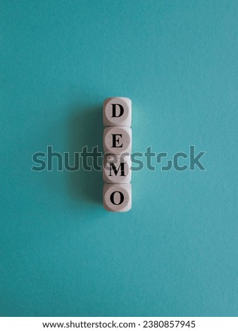 The word Demo on wooden cubes. Blue background. An extensive concept of the word demo applied in different fields of activity. Business concept. Copy space.