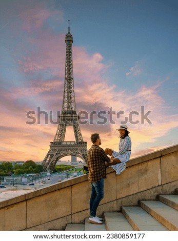 Young couple by Eiffel Tower at Sunrise, Paris Eifel Tower Sunrise man woman in love, valentine concept in Paris the city of love. Men and women visiting the Eiffel Tower. Royalty-Free Stock Photo #2380859177