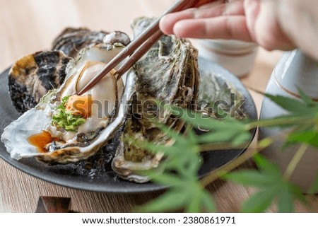 Raw oysters, ponzu and condiments Royalty-Free Stock Photo #2380861971