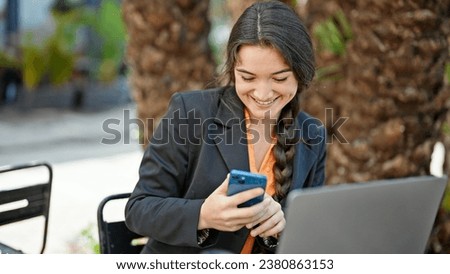 Young beautiful hispanic woman business worker make selfie by smartphone at park