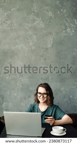 Seamless Shopping Experience: Young Woman with Credit Card Engaged in Online Transactions, Utilizing Laptop Computer for Convenient and Secure Online Shopping Royalty-Free Stock Photo #2380873117