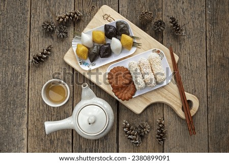 Top angle view of Songpyeon(half-moon-shaped rice cake) and Fried Rice Sweet with Yakgwa(Honey Cookie) and green tea on cutting board and wood floor, South Korea
 Royalty-Free Stock Photo #2380899091