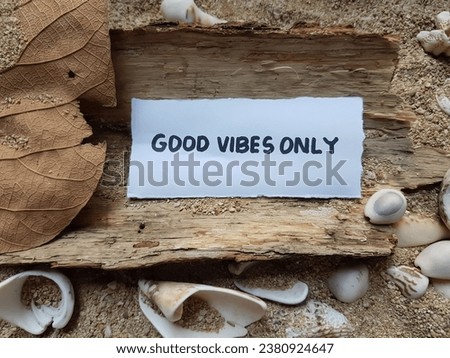 Good vibes only writing on beach sand background.