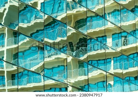 There is a distorted reflection in the mirrored windows. A sunny day. The concept of modern architecture