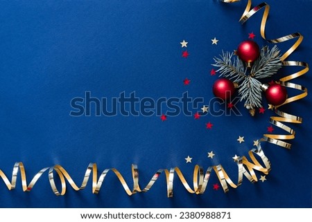 Christmas card banner with round balls toys, Christmas tree branches and golden decorative ribbon, glitter stars and bokeh lights. Mockup for your congratulations. Blue background.