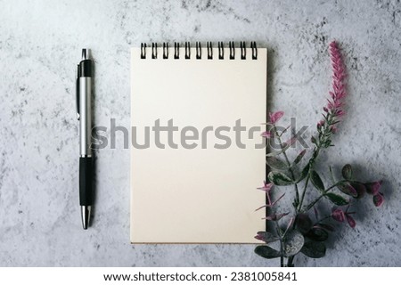 A book, pen and flower is placed on white background