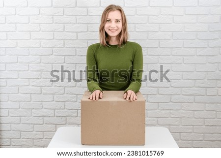 Pretty young woman with parcel box. Delivering a parcel