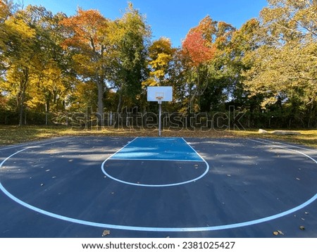 A shady basketball half-court in autumn at a children’s playground in Warwick, Rhode Island