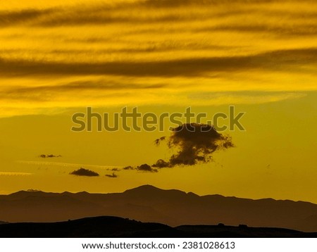 Abstract shape of the cloud. Smoke, evil face , halloween concept. Sunset time. End of the day. Dark brown mountain peak. Golden hour.