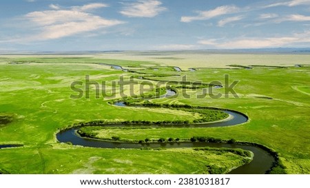 Panoramic view of beautiful countryside in the prairie of Inner Mongolia, China. Sunny afternoon. Wonderful spring landscape in the mountains. meadows and rolling hills. Royalty-Free Stock Photo #2381031817