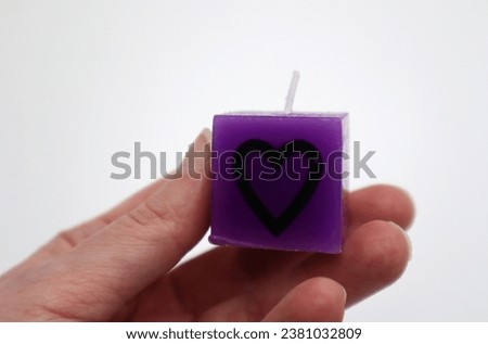 Hand holding candlelight cube light with heart sign decoration celebrating love and romantic gestures