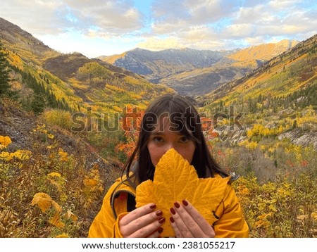 Big fall leaf with a woman and fall mountain scene