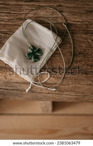 handmade ceramic pendant green four-leaf clover overhead view on wooden background