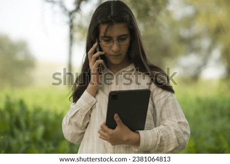 Young business woman having a job interview on the phone, doing business analysis, in the garden of the office, by the lake Royalty-Free Stock Photo #2381064813