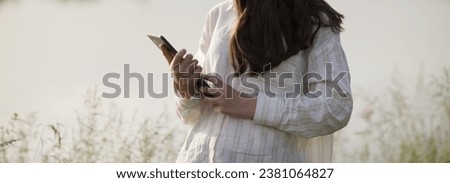 Young business woman having a job interview on the phone, doing business analysis, in the garden of the office, by the lake Royalty-Free Stock Photo #2381064827
